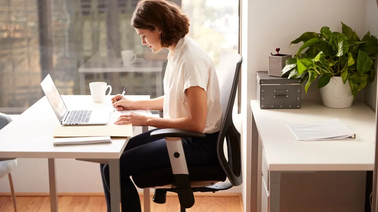 A professional writing at her desk